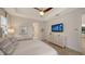 Well-lit bedroom with a ceiling fan, dresser with TV, and neutral decor at 14510 Leopard Creek Pl, Lakewood Ranch, FL 34202