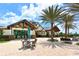 Luxurious clubhouse featuring outdoor seating, palm trees, and well-manicured landscaping at 14510 Leopard Creek Pl, Lakewood Ranch, FL 34202
