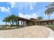 Beautiful community center featuring porte cochere, lush landscaping, and brick driveway on sunny day at 14510 Leopard Creek Pl, Lakewood Ranch, FL 34202