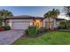 Charming home exterior with well-manicured landscaping, brick driveway, and a two-car garage at 14510 Leopard Creek Pl, Lakewood Ranch, FL 34202