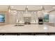 Open kitchen with stainless steel appliances, large center island, and stylish overhead lighting at 14510 Leopard Creek Pl, Lakewood Ranch, FL 34202