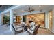 Inviting outdoor patio with stone floors, fire pit, ceiling fan, and access to the home's interior at 14510 Leopard Creek Pl, Lakewood Ranch, FL 34202