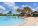 Community pool with splash fountain, surrounded by palm trees and offering a refreshing amenity at 14510 Leopard Creek Pl, Lakewood Ranch, FL 34202