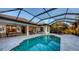 Inviting backyard with a screened-in pool, outdoor dining, kitchen, and comfortable seating area at 14510 Leopard Creek Pl, Lakewood Ranch, FL 34202