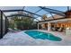 Serene backyard featuring a screened-in pool, sun loungers, and lush tropical landscaping at 14510 Leopard Creek Pl, Lakewood Ranch, FL 34202