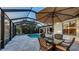 Poolside outdoor dining area with umbrella, lounge chairs, and screened enclosure for relaxation at 14510 Leopard Creek Pl, Lakewood Ranch, FL 34202