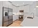 Bright kitchen featuring stainless steel appliances, wood-look floors, white cabinets, and quartz countertops at 1500 State St # 305, Sarasota, FL 34236