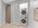 Efficient laundry room with stacked washer and dryer, and natural wood colored tile at 1500 State St # 305, Sarasota, FL 34236