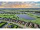 Aerial view of neighborhood showcasing waterfront homes, beautiful landscaping, lake, and community golf course at 15115 Montello Way, Lakewood Ranch, FL 34211
