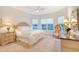 Bright bedroom features a large bed, elegant furnishings, neutral carpet, and ample natural light from the surrounding windows at 15115 Montello Way, Lakewood Ranch, FL 34211
