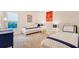 Bright bedroom with matching twin beds, neutral carpeting, and colorful paintings adorning the walls at 15115 Montello Way, Lakewood Ranch, FL 34211