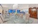 Bright dining room with modern chandelier, glass table, and sliding glass doors that lead to the lanai at 15115 Montello Way, Lakewood Ranch, FL 34211