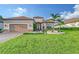 Charming front exterior with well-manicured lawn, paver driveway, mature palm trees, and a two-car garage at 15115 Montello Way, Lakewood Ranch, FL 34211