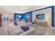 Open-concept living space with white couches, accent wall, modern furniture, tile flooring, and open access to the dining area at 15115 Montello Way, Lakewood Ranch, FL 34211