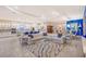 Open-concept living space with white kitchen, modern furniture, tile flooring, and open access to the dining area at 15115 Montello Way, Lakewood Ranch, FL 34211
