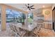 Covered outdoor dining area with a table for eight, a full kitchen, and lake views at 15115 Montello Way, Lakewood Ranch, FL 34211