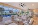 Covered outdoor patio with comfortable seating area, full kitchen, and a view of the pool and lake at 15115 Montello Way, Lakewood Ranch, FL 34211