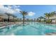 Expansive community pool area with palm trees, lounge chairs, and an inviting Bahama Bar under a sunny, cloud-filled sky at 15115 Montello Way, Lakewood Ranch, FL 34211