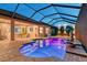 Private, screened-in pool at night with integrated fountain feature, surrounding tile and outdoor lighting at 15115 Montello Way, Lakewood Ranch, FL 34211