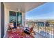 Relaxing outdoor balcony offers city views, seating, rug and glass doors for indoor/outdoor living at 1771 Ringling Blvd # 703, Sarasota, FL 34236