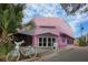 Exterior view of the pink Sarasota Film Society building with bicycle and foliage at 1771 Ringling Blvd # 703, Sarasota, FL 34236