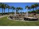 Community fountain with tall palm trees in a landscaped outdoor space on a bright, sunny day at 1771 Ringling Blvd # 703, Sarasota, FL 34236