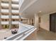 Bright hallway overlooking interior atrium with seating and multiple residential doors at 1771 Ringling Blvd # 703, Sarasota, FL 34236