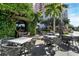 Outdoor restaurant patio with modern gray chairs, tables, shade and tropical foliage at 1771 Ringling Blvd # 703, Sarasota, FL 34236