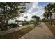 Sidewalk with benches along the bay offering scenic views and palm trees and a blue sky at 1771 Ringling Blvd # 703, Sarasota, FL 34236