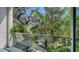 A cozy balcony features a glass railing and a lush, tropical landscape at 211 Cosmopolitan Ct # 211, Sarasota, FL 34236