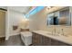 Bright bathroom featuring double vanity, soaking tub, large mirror and modern fixtures at 211 Cosmopolitan Ct # 211, Sarasota, FL 34236