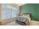 Stylish bedroom with a large window, a soothing green accent wall, and neutral-toned bedding at 211 Cosmopolitan Ct # 211, Sarasota, FL 34236