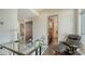 A modern office features a glass desk, sleek chair, and minimalist decor creating a stylish workspace at 211 Cosmopolitan Ct # 211, Sarasota, FL 34236