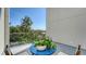 Relaxing patio with a blue table, chairs, and potted plants, surrounded by lush green trees at 211 Cosmopolitan Ct # 211, Sarasota, FL 34236