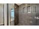 Modern shower with sleek gray tile, glass enclosure, and built-in shelving creating a spa-like experience at 211 Cosmopolitan Ct # 211, Sarasota, FL 34236