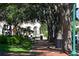 Beautiful street view with mature trees and park benches along the brick sidewalks at 211 Cosmopolitan Ct # 211, Sarasota, FL 34236