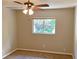 Cozy bedroom with a ceiling fan, neutral walls, carpet flooring, and a window for natural light at 2240 Raywood Ave, North Port, FL 34286