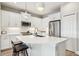 Bright kitchen featuring an island with seating, stainless steel appliances, and white cabinets at 244 Tracino Ter, Nokomis, FL 34275