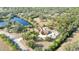 Aerial view displaying the home with a pool and an adjacent lake, surrounded by lush trees and greenery at 265 Beaver Ct, Venice, FL 34292