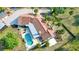 Aerial view showcasing the pool, patio, and tile roof, set among manicured lawns and mature trees at 265 Beaver Ct, Venice, FL 34292