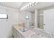 Bathroom with double sinks, floral wallpaper, tub/shower combo, and ample natural light at 265 Beaver Ct, Venice, FL 34292