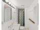 All-white bathroom with shower stall, tiled flooring, and traditional vanity mirror with sconce lighting at 265 Beaver Ct, Venice, FL 34292
