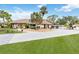 Lovely single-story home featuring a tile roof, mature landscaping, and an expansive driveway leading to a three-car garage at 265 Beaver Ct, Venice, FL 34292
