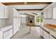 Bright, open kitchen leading to the Gathering room with wooden beams and stone fireplace at 265 Beaver Ct, Venice, FL 34292