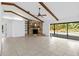 Spacious living room featuring a stone fireplace, wood beam ceiling, and sliding glass doors to the pool at 265 Beaver Ct, Venice, FL 34292