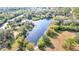 Aerial view of a large pond, bordered by lush trees and native vegetation, highlighting natural surroundings at 265 Beaver Ct, Venice, FL 34292