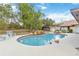 Private backyard featuring a kidney-shaped pool with a waterfall feature, a deck, and lush landscaping at 265 Beaver Ct, Venice, FL 34292
