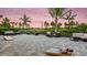 A community space with multiple outdoor chairs, tables, and yard games to enjoy under the palms and string lights at 26891 Victoria Pl, Punta Gorda, FL 33955