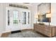 Elegant foyer features a glass-paneled front door, stylish console table, and modern artwork at 26891 Victoria Pl, Punta Gorda, FL 33955