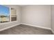 Bedroom with wood-look tile flooring and a large window offering natural light and neighborhood views at 26902 Victoria Pl, Punta Gorda, FL 33955